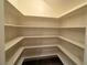 Pantry with tiered, wrap-around, built-in white shelving and tile floors at 26 E Serene Ave # 412, Las Vegas, NV 89123