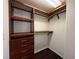 Walk-in closet with custom shelving, drawers, and wood toned finishes at 26 E Serene Ave # 412, Las Vegas, NV 89123