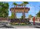 Elegant entrance to Las Vegas Country Club Estates featuring stone pillars and mature palm trees at 2819 Queens Courtyard Dr, Las Vegas, NV 89109
