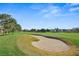 Well-maintained golf course with a sand trap in the foreground and surrounding trees at 2819 Queens Courtyard Dr, Las Vegas, NV 89109