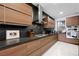 Stylish kitchen with wooden cabinets, black countertops, and stainless steel appliances, showcasing modern design at 2819 Queens Courtyard Dr, Las Vegas, NV 89109