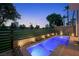 Beautiful backyard featuring a pool, lush landscaping, and distant cityscape views, perfect for tranquil outdoor living at 2819 Queens Courtyard Dr, Las Vegas, NV 89109