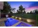 Stunning pool area with a lush green lawn, perfect for outdoor relaxation and recreation at sunset at 2819 Queens Courtyard Dr, Las Vegas, NV 89109