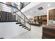 Modern staircase leading to the kitchen with stainless steel railings and open floorplan design at 2819 Queens Courtyard Dr, Las Vegas, NV 89109