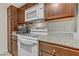 Kitchen with white oven and microwave, wood cabinets, granite countertops, and convenient appliances at 2831 Geary Pl # 2912, Las Vegas, NV 89109