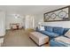Cozy living room with a blue sofa, striped ottoman, decorative mirror, and open access to the dining area at 2831 Geary Pl # 2912, Las Vegas, NV 89109