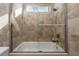 This bathroom features tile walls, a bathtub, a glass door, and a shower with great lighting at 2917 Chapala Dr, Las Vegas, NV 89120