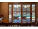 Cozy dining area with a wood table and chairs, offering a view of the inviting backyard pool at 2917 Chapala Dr, Las Vegas, NV 89120