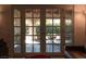 View through glass doors reveals an elegant outdoor patio setup with furniture and lush landscaping at 2917 Chapala Dr, Las Vegas, NV 89120
