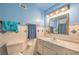Bathroom with a toilet, sink and storage cabinet with a large mirror and white and blue tile at 3567 Horizon Cir, Las Vegas, NV 89121