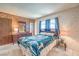 Comfortable bedroom featuring a queen bed, large window, wood walls and neutral decor at 3567 Horizon Cir, Las Vegas, NV 89121