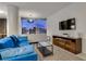 Comfortable living room with a blue sofa, a modern media center, and city views at 3726 Las Vegas Blvd # 2407, Las Vegas, NV 89158