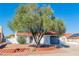 Charming front yard featuring a mature tree and red rock landscaping at 451 Concord Way, Henderson, NV 89015