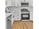 Bright kitchen featuring white cabinetry, stainless steel appliances, and light wood flooring at 451 Concord Way, Henderson, NV 89015