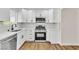 Bright kitchen featuring white cabinets, stainless steel appliances, and wood-look flooring at 451 Concord Way, Henderson, NV 89015