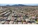 Wide aerial shot of a neighborhood displaying various homes, streets, and mountain views against a clear blue sky at 460 Accelerando Way, Henderson, NV 89011