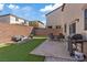 Lush backyard featuring artificial grass, a patio area with dining set, and a built-in grill, perfect for outdoor gatherings at 460 Accelerando Way, Henderson, NV 89011
