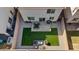 Aerial view of a landscaped backyard with artificial grass, patio, dining, and fire pit seating areas, surrounded by gravel at 460 Accelerando Way, Henderson, NV 89011