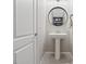 Half bath features pedestal sink and round mirror at 460 Accelerando Way, Henderson, NV 89011