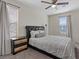 Inviting bedroom with a patterned bedspread, nightstand, and window with blinds at 460 Accelerando Way, Henderson, NV 89011