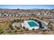 Aerial view of a community pool and park featuring lush landscaping, a water play area, and covered seating at 460 Accelerando Way, Henderson, NV 89011