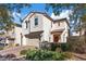 Charming two-story stucco home with a red tile roof, lush landscaping, and a two-car garage at 460 Accelerando Way, Henderson, NV 89011