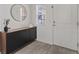 Light-filled entryway with a dark cabinet, round mirror, and tiled floors at 460 Accelerando Way, Henderson, NV 89011
