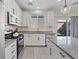Well-lit kitchen with stainless steel appliances, white cabinets, and granite countertops overlooking the backyard at 460 Accelerando Way, Henderson, NV 89011