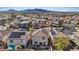 Aerial view of a residential neighborhood featuring houses with solar panels, lush landscaping, and mountain views in the distance at 460 Accelerando Way, Henderson, NV 89011
