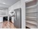 Spacious kitchen with stainless steel refrigerator, white cabinets, black appliances, and an open pantry at 4837 Morning Splash Ave, Las Vegas, NV 89131