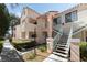 Inviting condo with exterior stairs, landscaped grounds, and a light pink facade at 4861 S Torrey Pines Dr # 106, Las Vegas, NV 89103