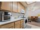 Cozy kitchen with light wood cabinets and white appliances overlooks a dining area at 4861 S Torrey Pines Dr # 106, Las Vegas, NV 89103
