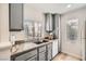 Charming kitchen featuring gray cabinets, granite countertops, and a bright window over the sink at 4899 S Torrey Pines Dr # 104, Las Vegas, NV 89103