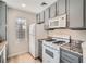 Kitchen featuring gray cabinets, granite countertops, white appliances, and a window at 4899 S Torrey Pines Dr # 104, Las Vegas, NV 89103