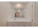 Bright bathroom vanity with white countertops, white cabinets, and a large mirror and decorative towel rings at 542 Foothill Cove Ln, Henderson, NV 89002