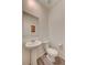 Clean half-bathroom with modern pedestal sink, toilet, and wood-look floors at 542 Foothill Cove Ln, Henderson, NV 89002