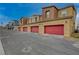 Townhomes featuring red garage doors and stucco exteriors at 542 Foothill Cove Ln, Henderson, NV 89002
