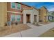 Inviting townhome exterior with neutral stucco, small front yard, and covered front porch at 542 Foothill Cove Ln, Henderson, NV 89002