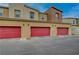 Townhomes with a view of red garage doors and stucco exteriors at 542 Foothill Cove Ln, Henderson, NV 89002