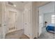 Hallway with a view of the bathroom with a white toilet and the bedroom with a queen bed at 542 Foothill Cove Ln, Henderson, NV 89002