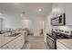 Open kitchen features white cabinetry, modern stainless steel appliances and laminate flooring at 542 Foothill Cove Ln, Henderson, NV 89002