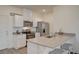 Charming kitchen with laminate flooring, stainless steel appliances, and bright white cabinets at 542 Foothill Cove Ln, Henderson, NV 89002