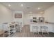 Open-concept kitchen with stainless steel appliances, white cabinets, and breakfast bar seating at 542 Foothill Cove Ln, Henderson, NV 89002