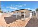 Expansive backyard featuring white siding, a covered patio, and potential for landscaping or outdoor activities at 6320 Hobart Ave, Las Vegas, NV 89107