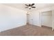 This bedroom features neutral carpet, a ceiling fan, and closet with shelving at 6320 Hobart Ave, Las Vegas, NV 89107
