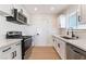 Well-lit kitchen featuring white cabinets, stainless steel appliances, and a stylish faucet at 6320 Hobart Ave, Las Vegas, NV 89107