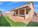 Spacious backyard with a covered patio, outdoor kitchen, artificial turf, and well-maintained landscaping for entertaining at 6335 Mount Eden Ave, Las Vegas, NV 89139
