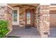 Close-up of the front entrance with a decorative wood door, brick columns, and manicured landscaping at 6335 Mount Eden Ave, Las Vegas, NV 89139