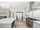 Modern kitchen features stainless steel appliances, white cabinets, an island, and wooden floor at 6335 Mount Eden Ave, Las Vegas, NV 89139