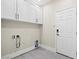 The clean laundry room features white cabinets and durable tile flooring at 6335 Mount Eden Ave, Las Vegas, NV 89139